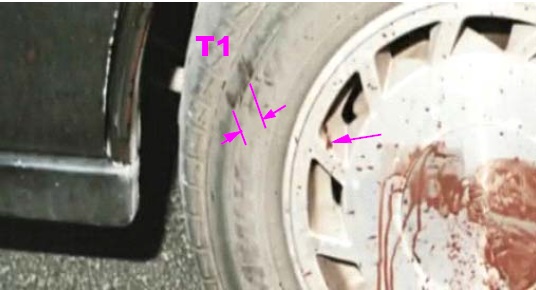 View of left rear tire showing sidewall markings likely made by edge thickness of assault weapon. A rough estimate of this thickness is one plus inches.